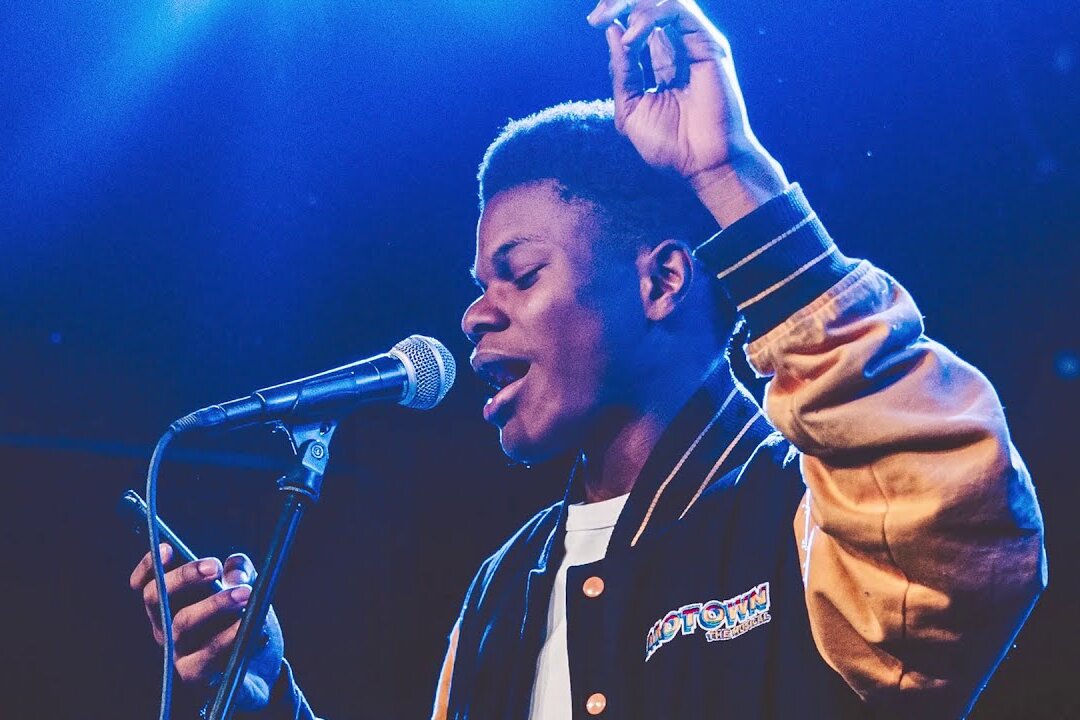 young man at microphone reading poetry