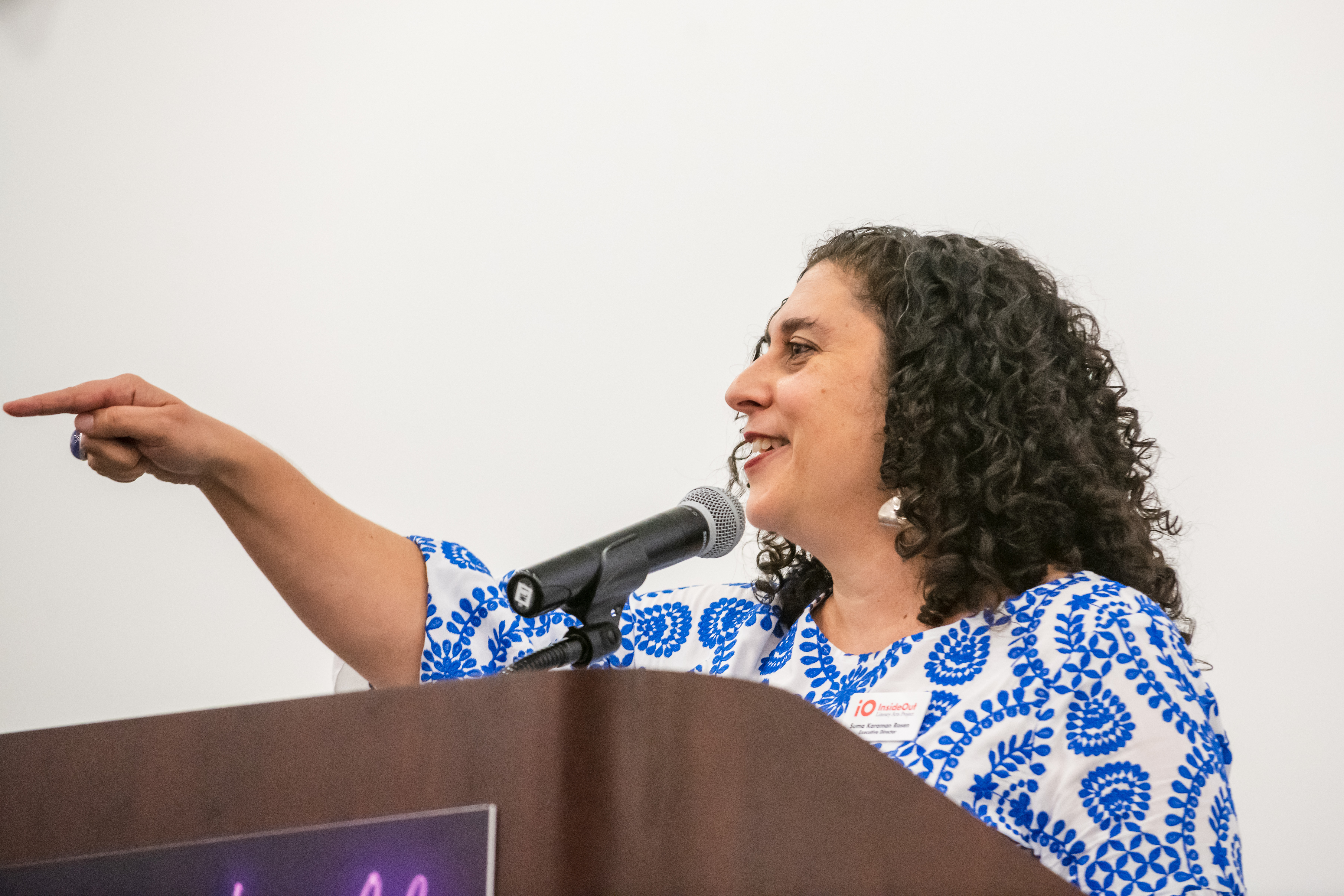 Suma Karaman Rosen points at students in the audience who are cheering her on as she starts to cry at an InsideOut Share the Light gala.